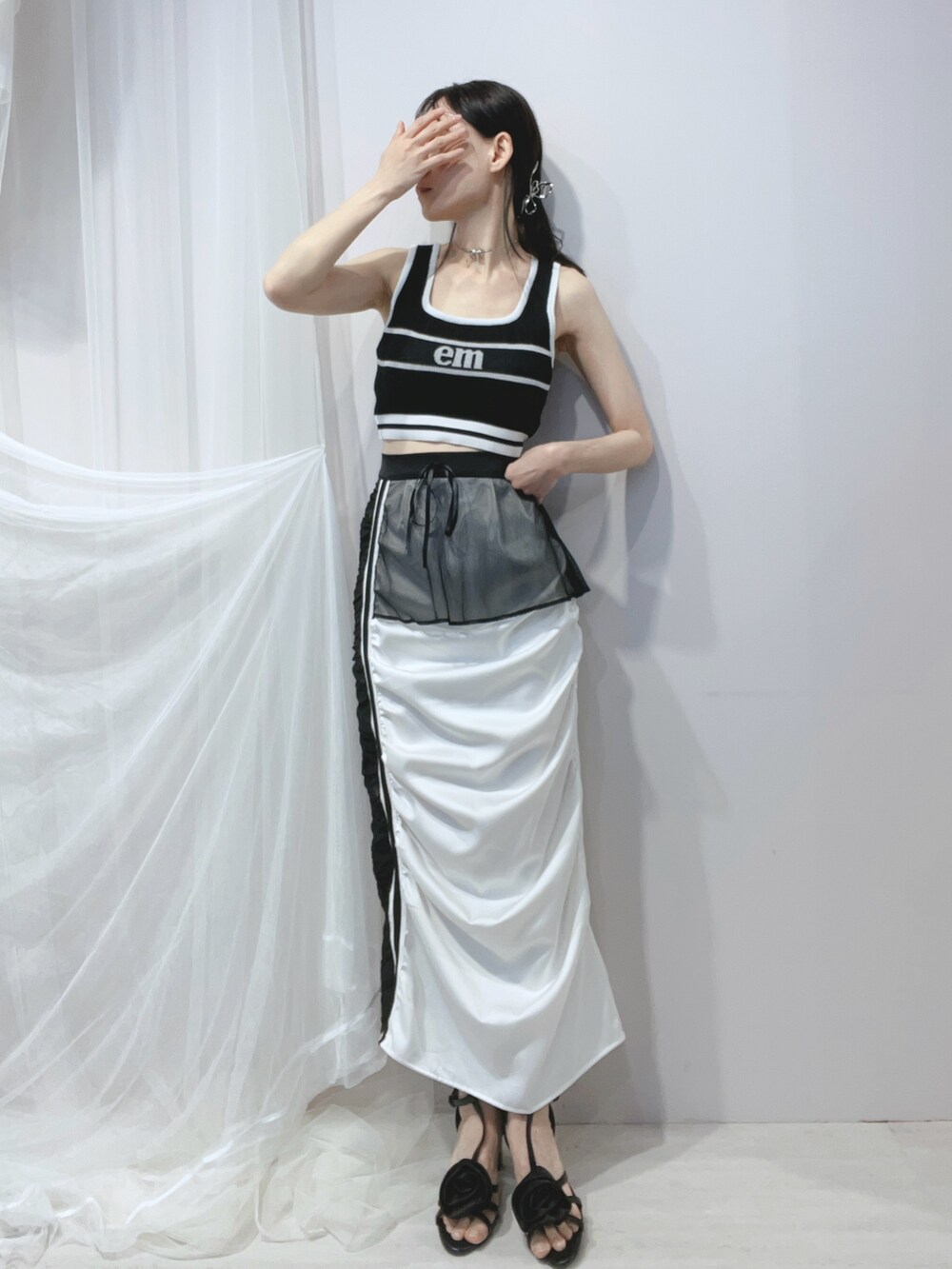 ブラック系のタンクトップ、ブラック系のハンドバッグ、ブラック系のサンダルを着用したレディースの春コーディネートの2枚目の写真