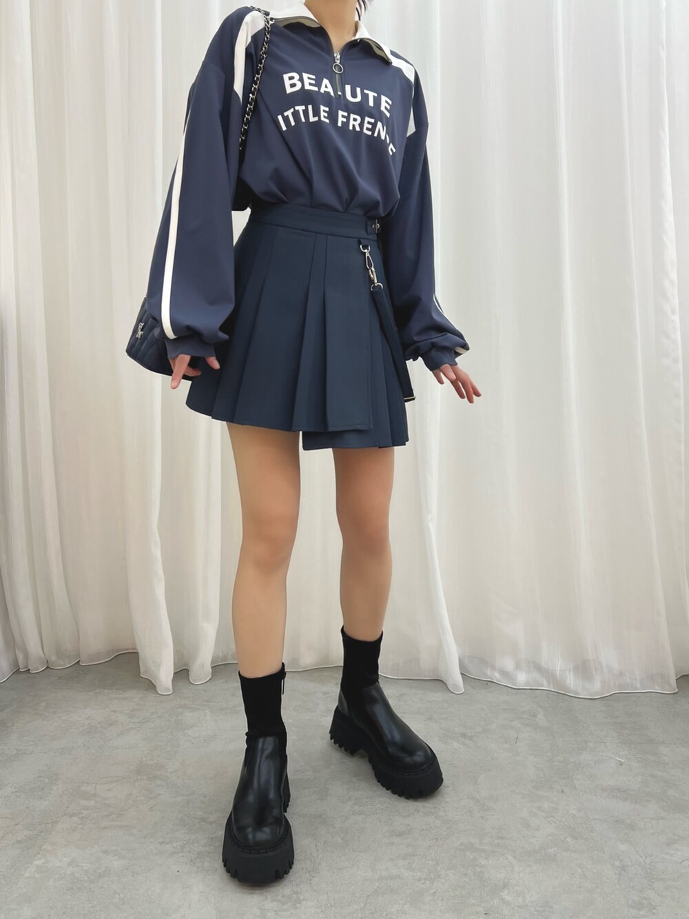 ブルー系のハンドバッグ、ブルー系のスカート、ブルー系のTシャツ/カットソーを着用したレディースの冬コーディネートの2枚目の写真