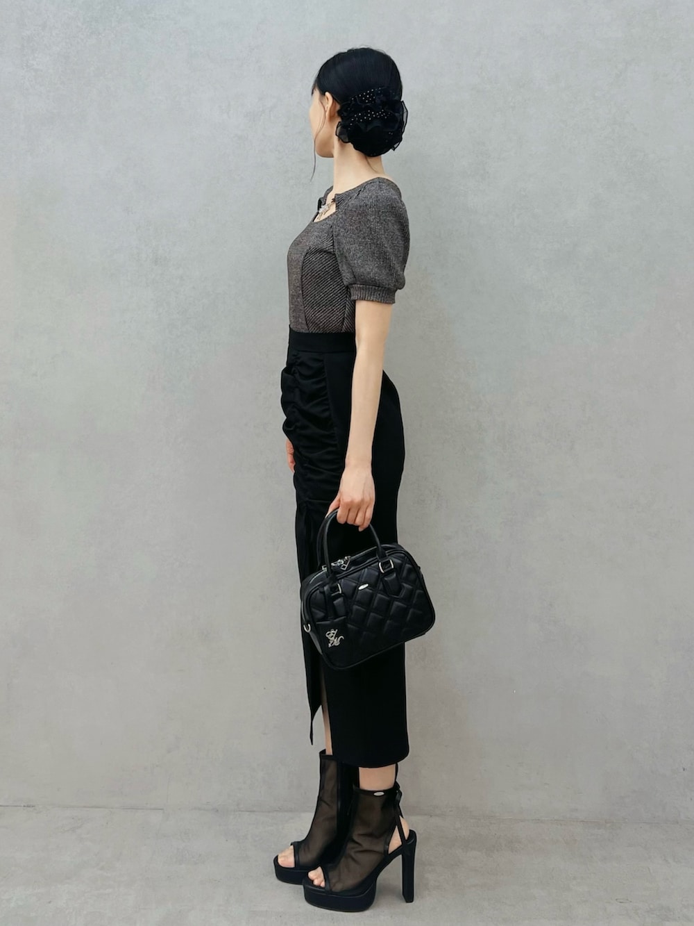 グレー系のTシャツ/カットソー、ブラック系のスカート、ブラック系のハンドバッグを着用したレディースの春コーディネートの2枚目の写真