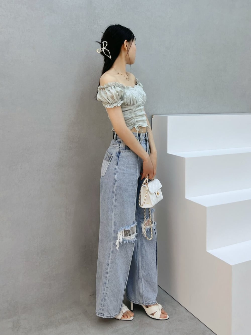ホワイト系のハンドバッグ、ブルー系のデニムパンツ、グリーン系のシャツ/ブラウスを着用したレディースの夏コーディネートの2枚目の写真