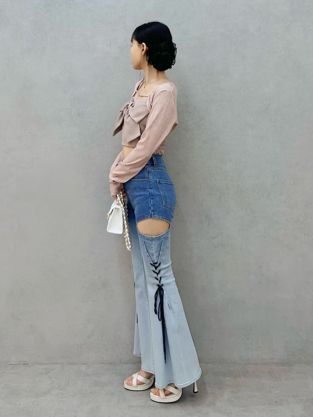 その他のデニムパンツ、ホワイト系のサンダル、ホワイト系のハンドバッグを着用したレディースの春コーディネートの2枚目の写真