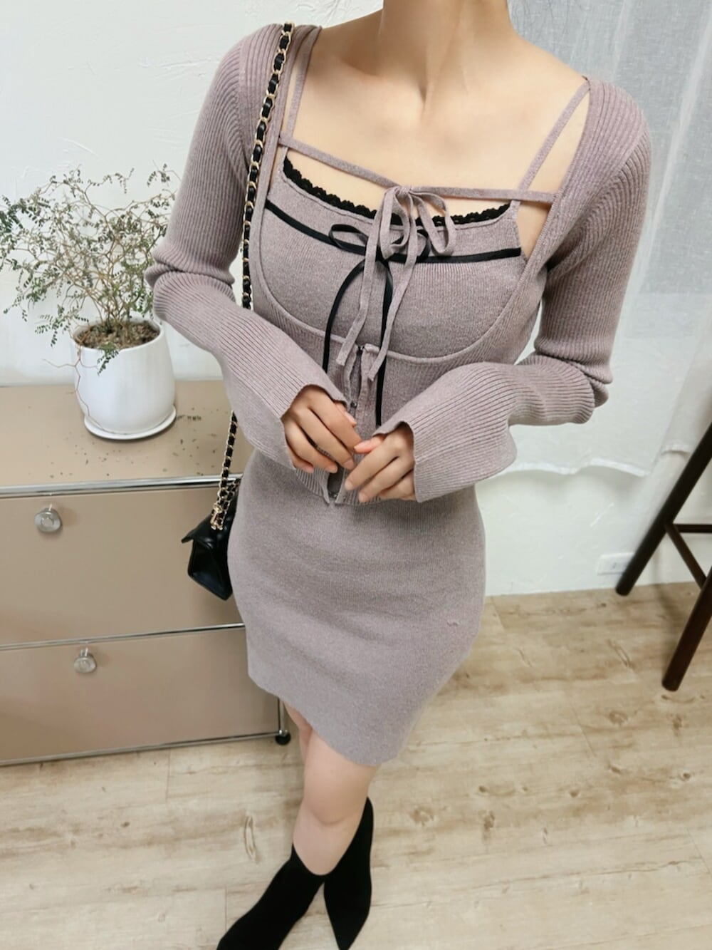 ブラック系のブーツ、ブラック系のハンドバッグ、ベージュ系のワンピースを着用したレディースの冬コーディネートの5枚目の写真