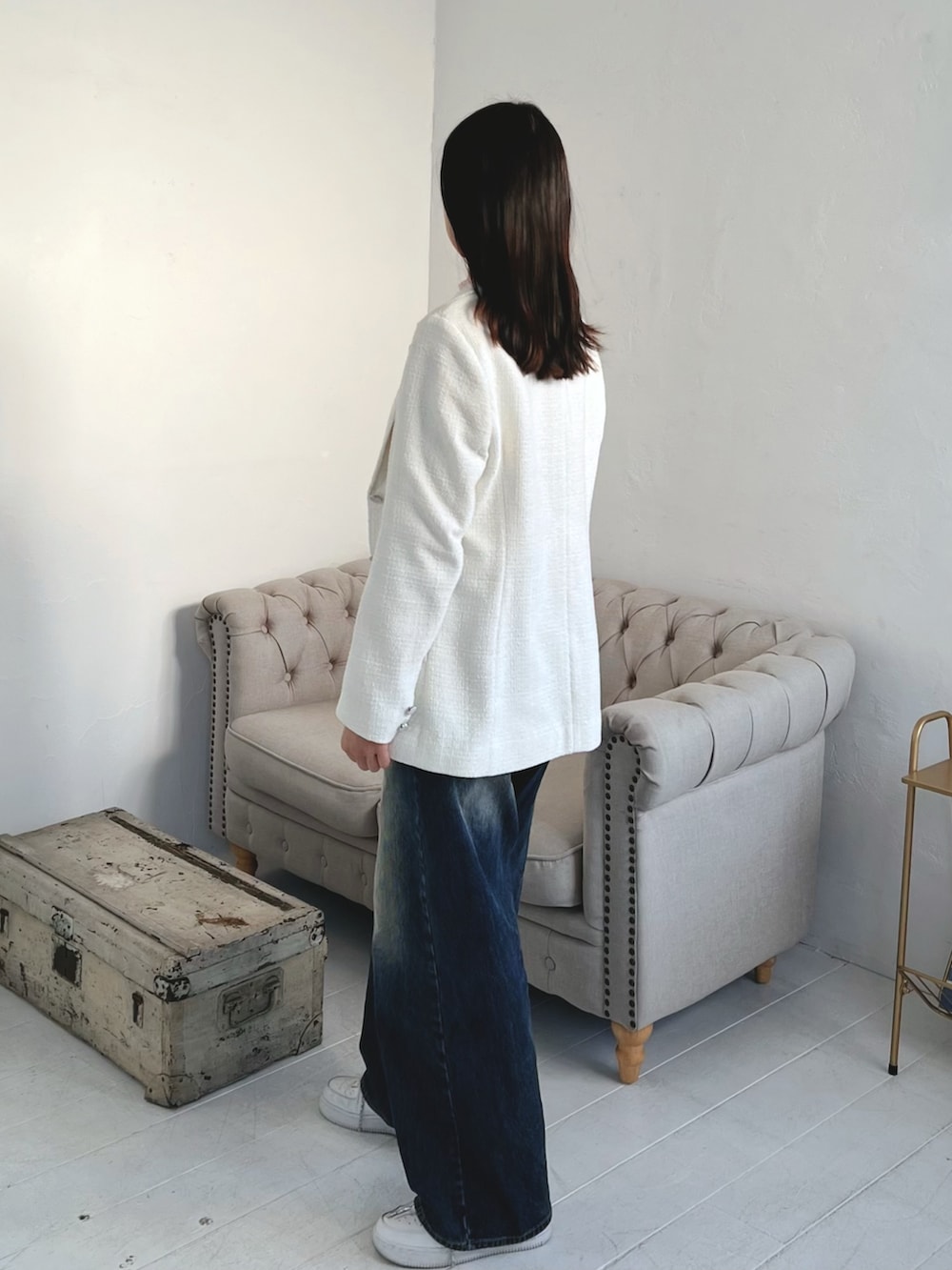 ホワイト系のテーラードジャケット、ブルー系のデニムパンツを着用したレディースの春コーディネートの2枚目の写真