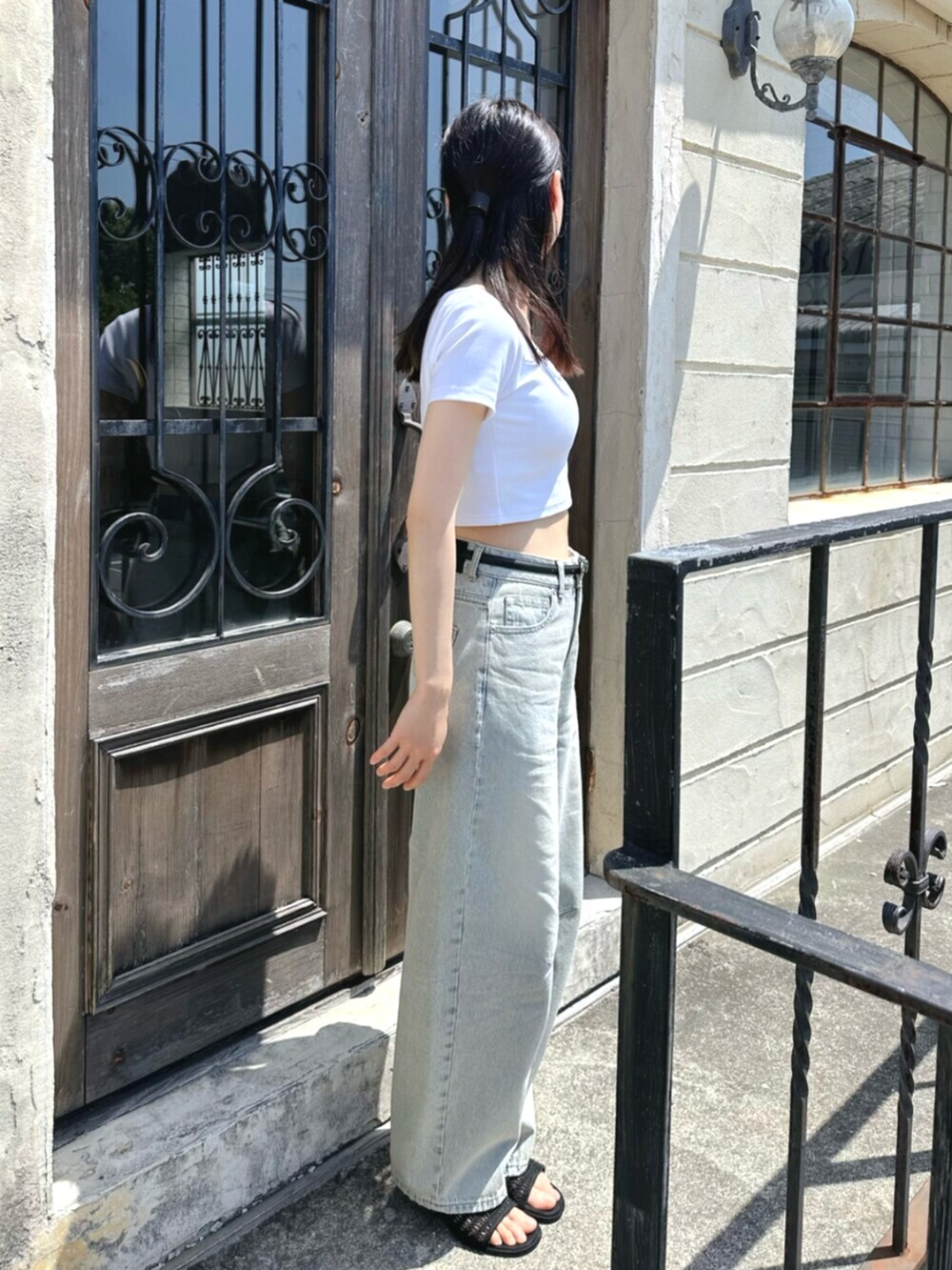 ホワイト系のTシャツ/カットソー、ブルー系のデニムパンツ、ブラック系のベルトを着用したレディースの夏コーディネートの3枚目の写真