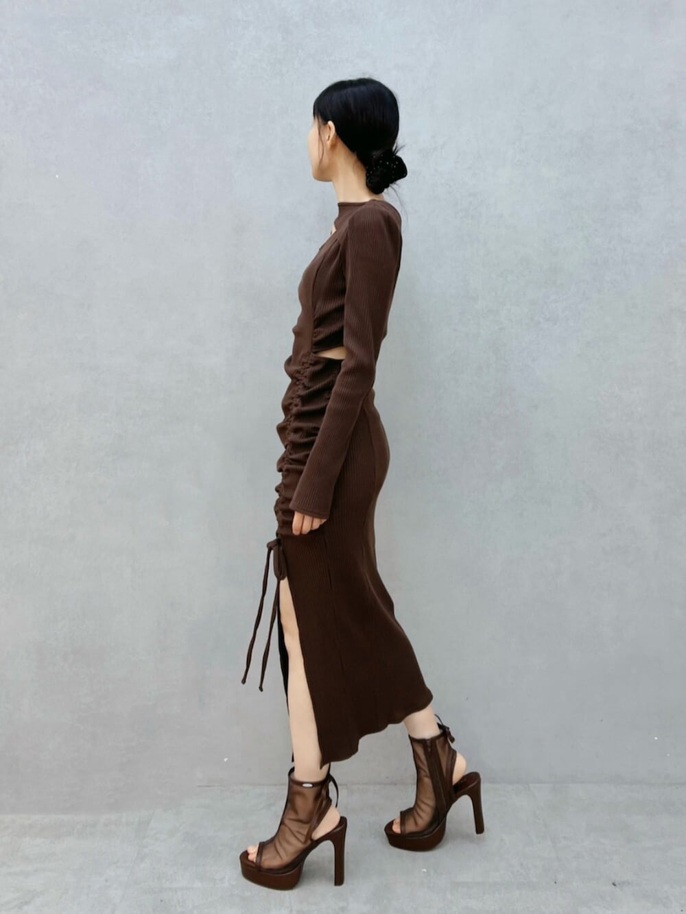 ブラウン系のサンダル、ブラック系のワンピースを着用したレディースの秋コーディネートの2枚目の写真