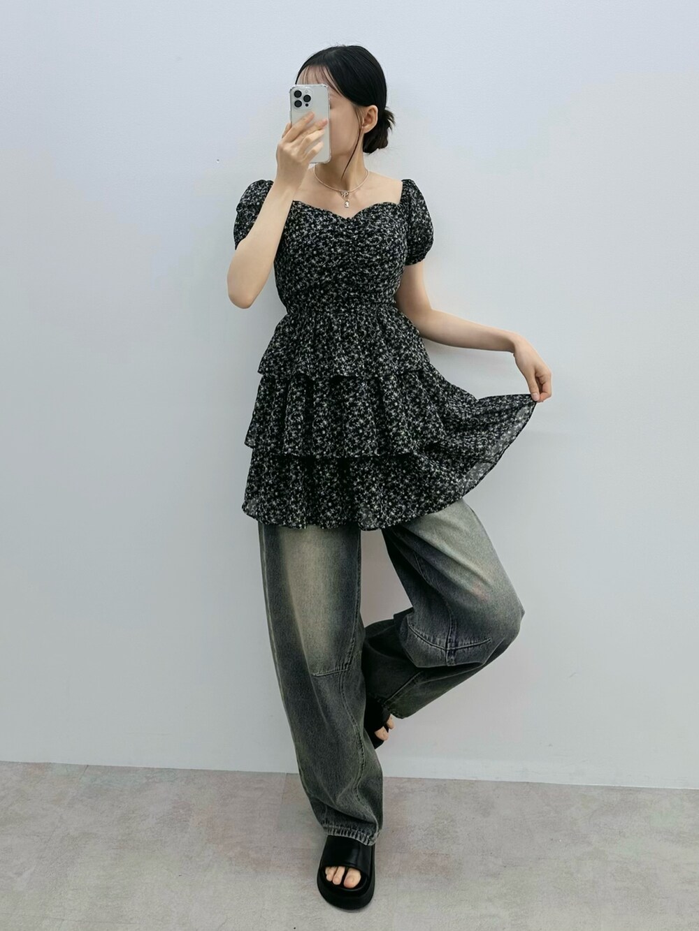 ブラック系のワンピース、ブルー系のデニムパンツ、シルバー系のネックレスを着用したレディースの夏コーディネートの2枚目の写真