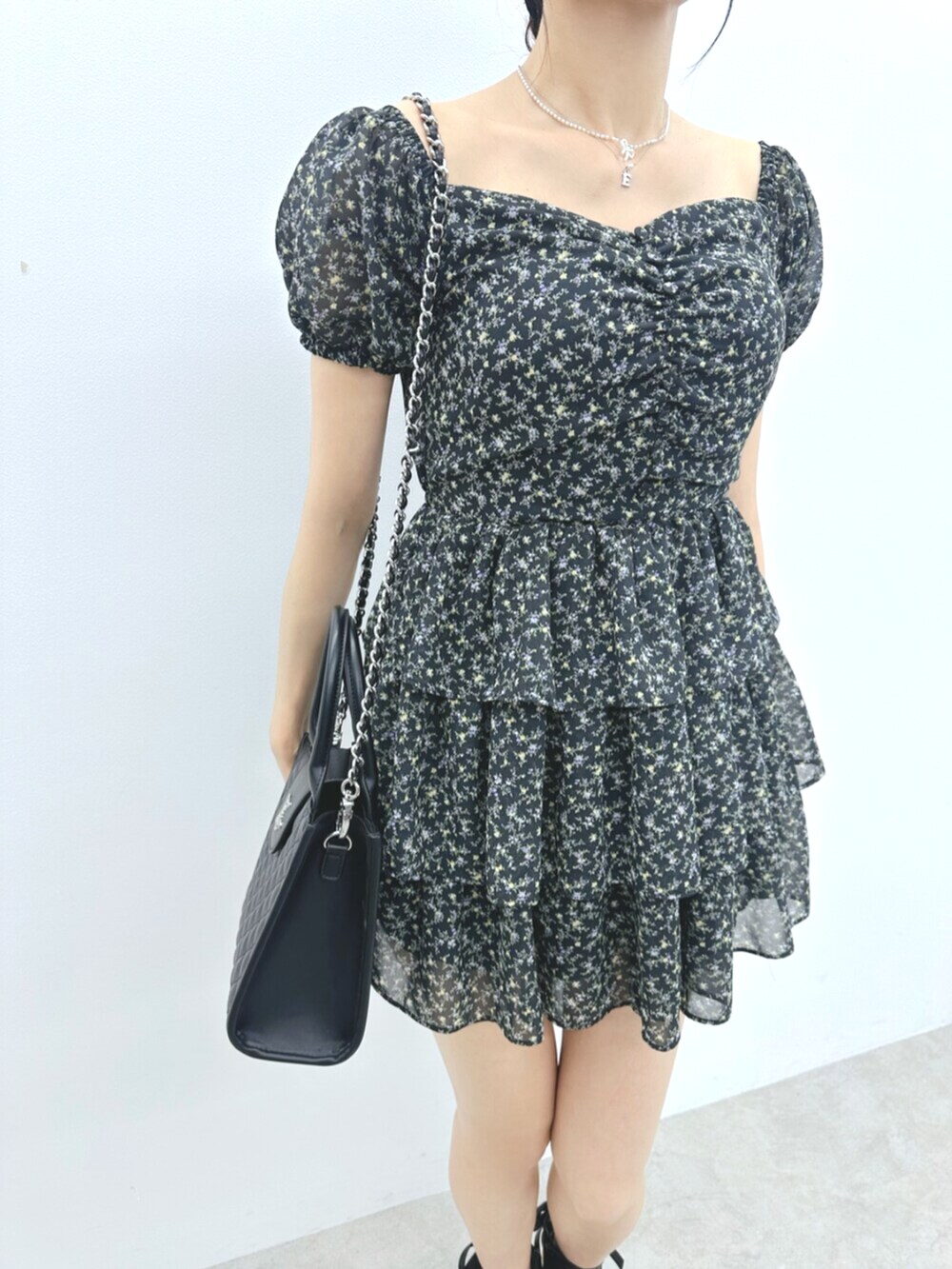 ブラック系のハンドバッグ、ブラック系のサンダル、ブラック系のワンピースを着用したレディースの夏コーディネートの5枚目の写真