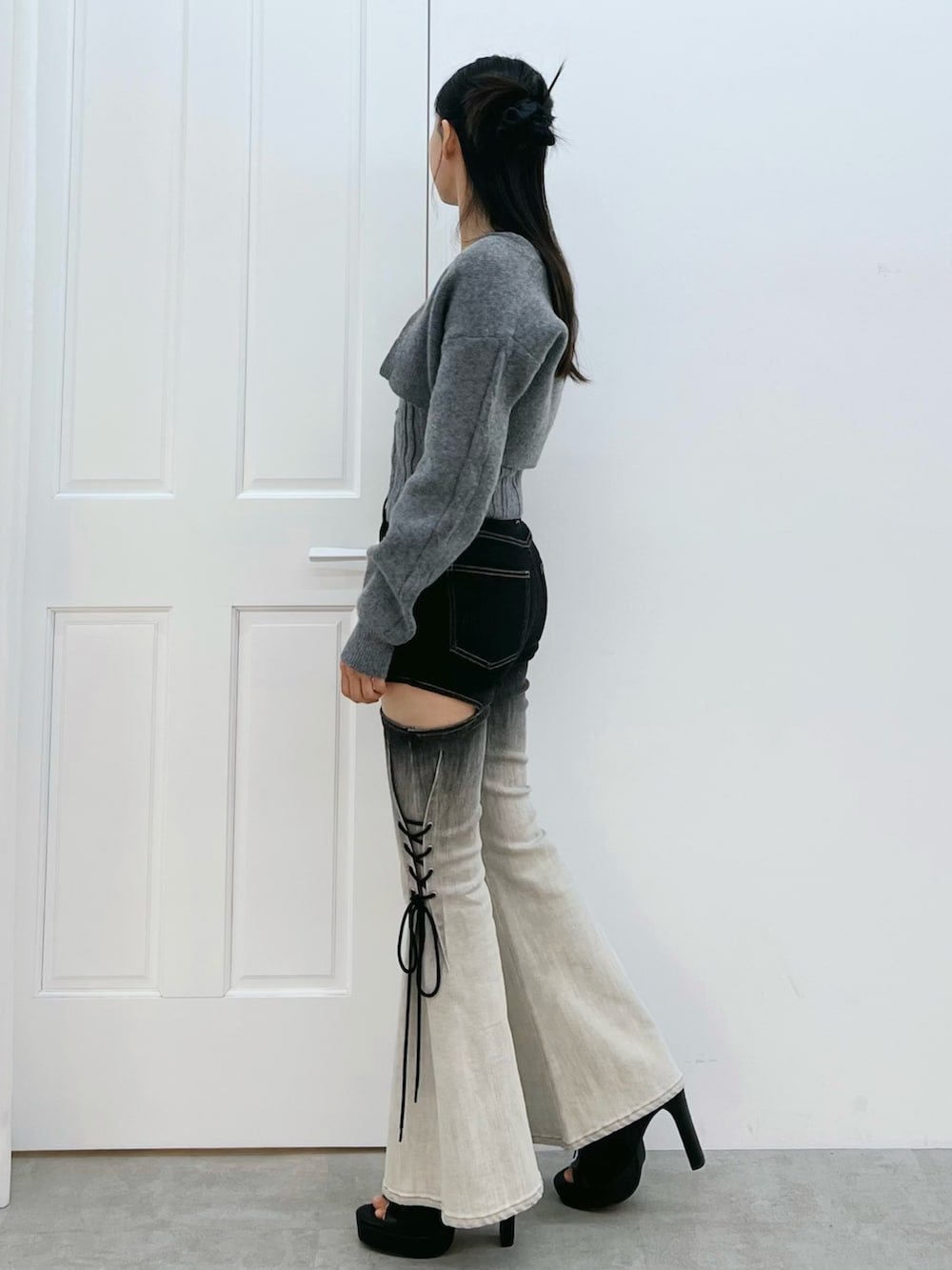 その他のデニムパンツ、グレー系のニット/セーター、ブラック系のブーツを着用したレディースの冬コーディネートの2枚目の写真