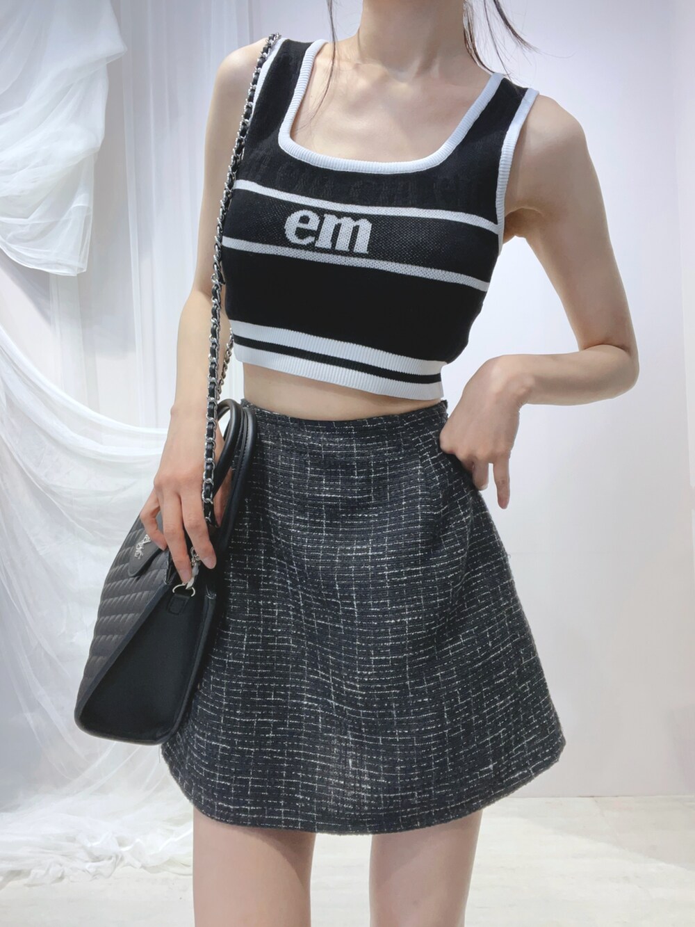 ブラック系のタンクトップ、ブラック系のハンドバッグ、ブラック系のサンダルを着用したレディースの春コーディネートの5枚目の写真