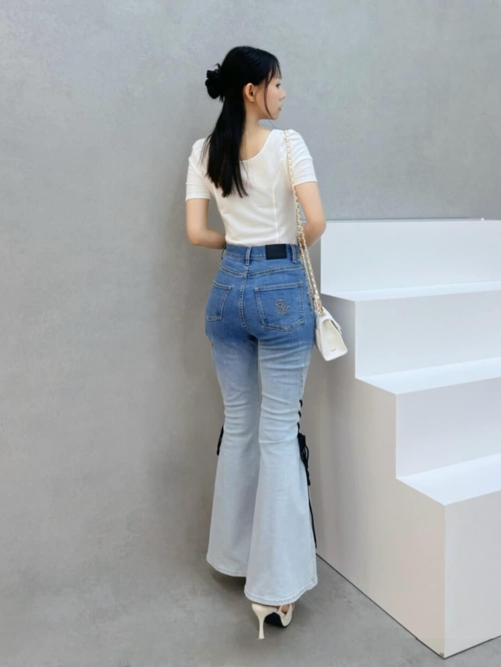 ホワイト系のハンドバッグ、ホワイト系のサンダル、その他のデニムパンツを着用したレディースの夏コーディネートの3枚目の写真