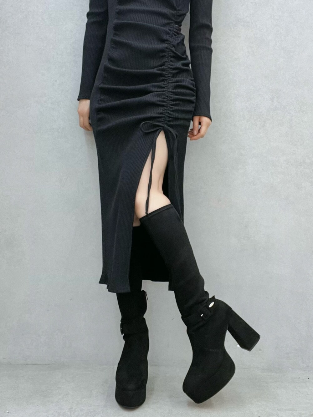 ブラック系のワンピース、ブラック系のブーツを着用したレディースの秋コーディネートの7枚目の写真