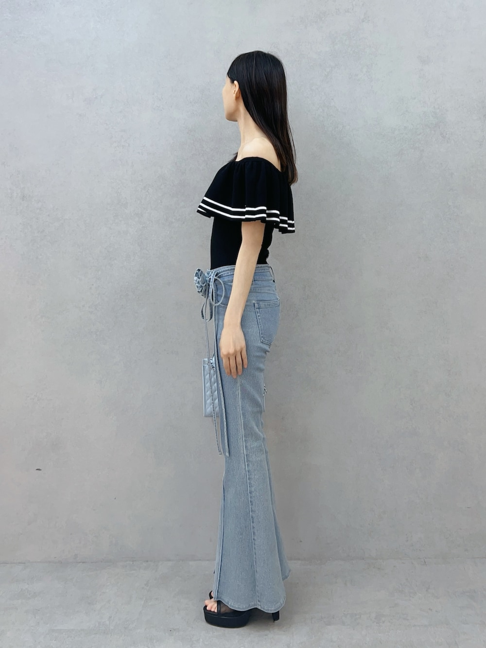 ブルー系のハンドバッグ、ブルー系のデニムパンツ、ブラック系のニット/セーターを着用したレディースの夏コーディネートの4枚目の写真