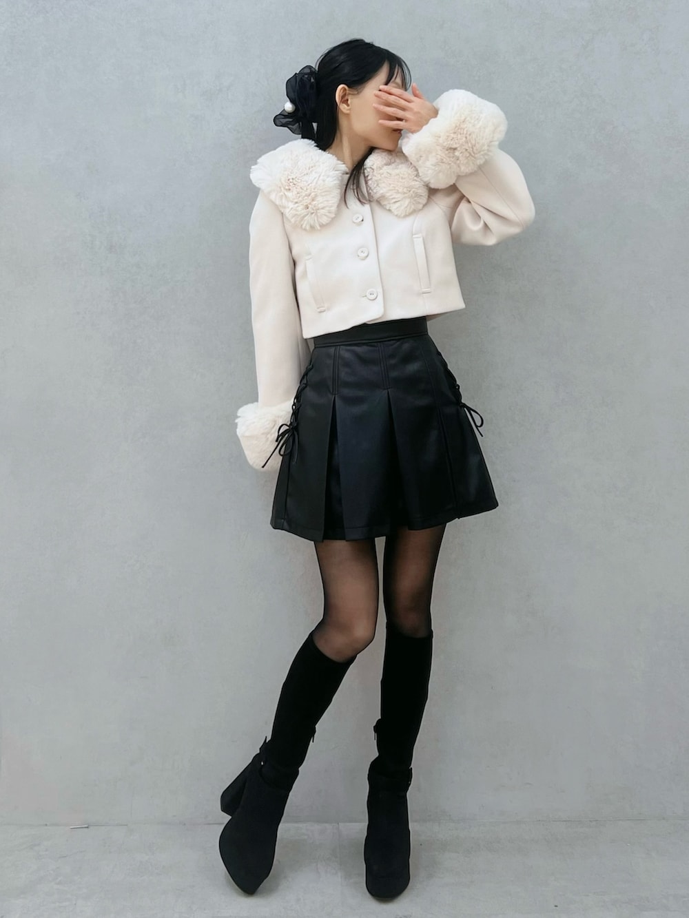 ブラック系のスカート、ホワイト系のその他アウター、ブラック系のブーツを着用したレディースの秋コーディネートの2枚目の写真