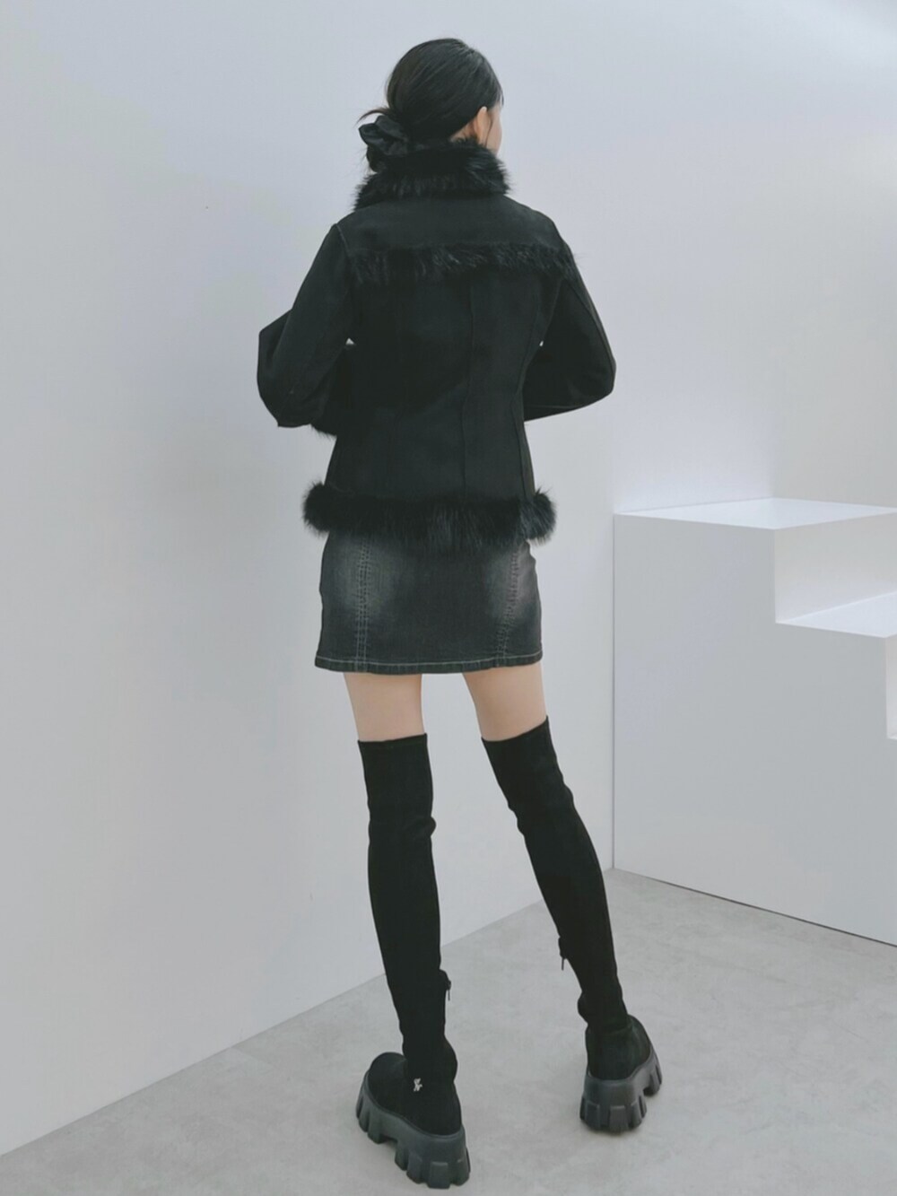 ブラック系のデニムスカート、ブラック系のブーツ、ブラック系のブルゾンを着用したレディースの秋コーディネートの4枚目の写真