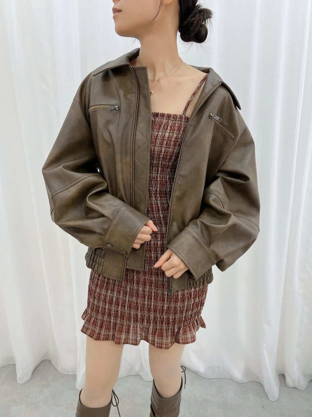 レッド系のワンピース、ブラウン系のブルゾン、ブラウン系のブーツを着用したレディースの秋コーディネートの6枚目の写真