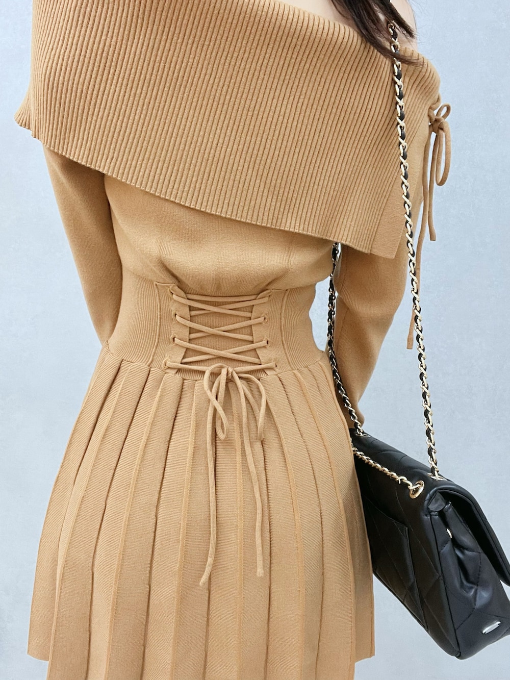 ブラウン系のワンピース、ブラウン系のブーツ、ブラック系のハンドバッグを着用したレディースの秋コーディネートの7枚目の写真