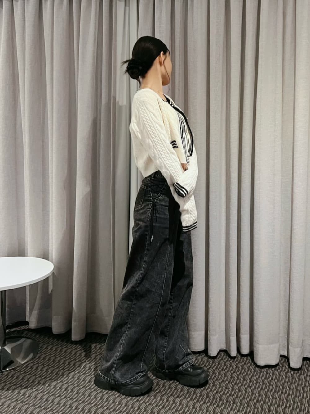ホワイト系のニット/セーター、ブラック系のデニムパンツ、ゴールド系のネックレスを着用したレディースの秋コーディネートの2枚目の写真