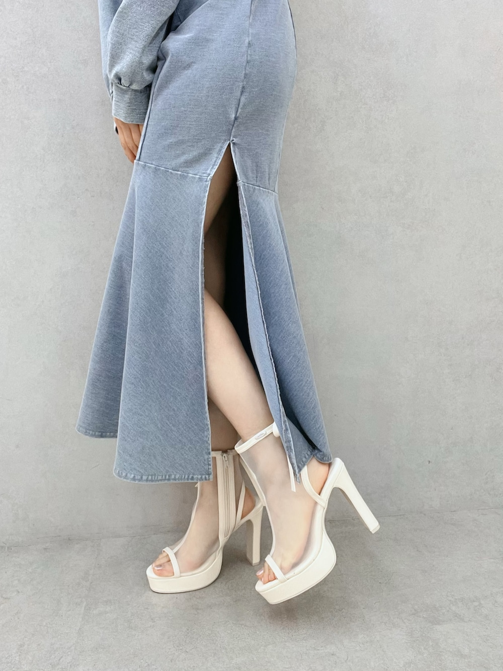 ブルー系のワンピース、ホワイト系のサンダル、ブルー系のパーカーを着用したレディースの春コーディネートの7枚目の写真