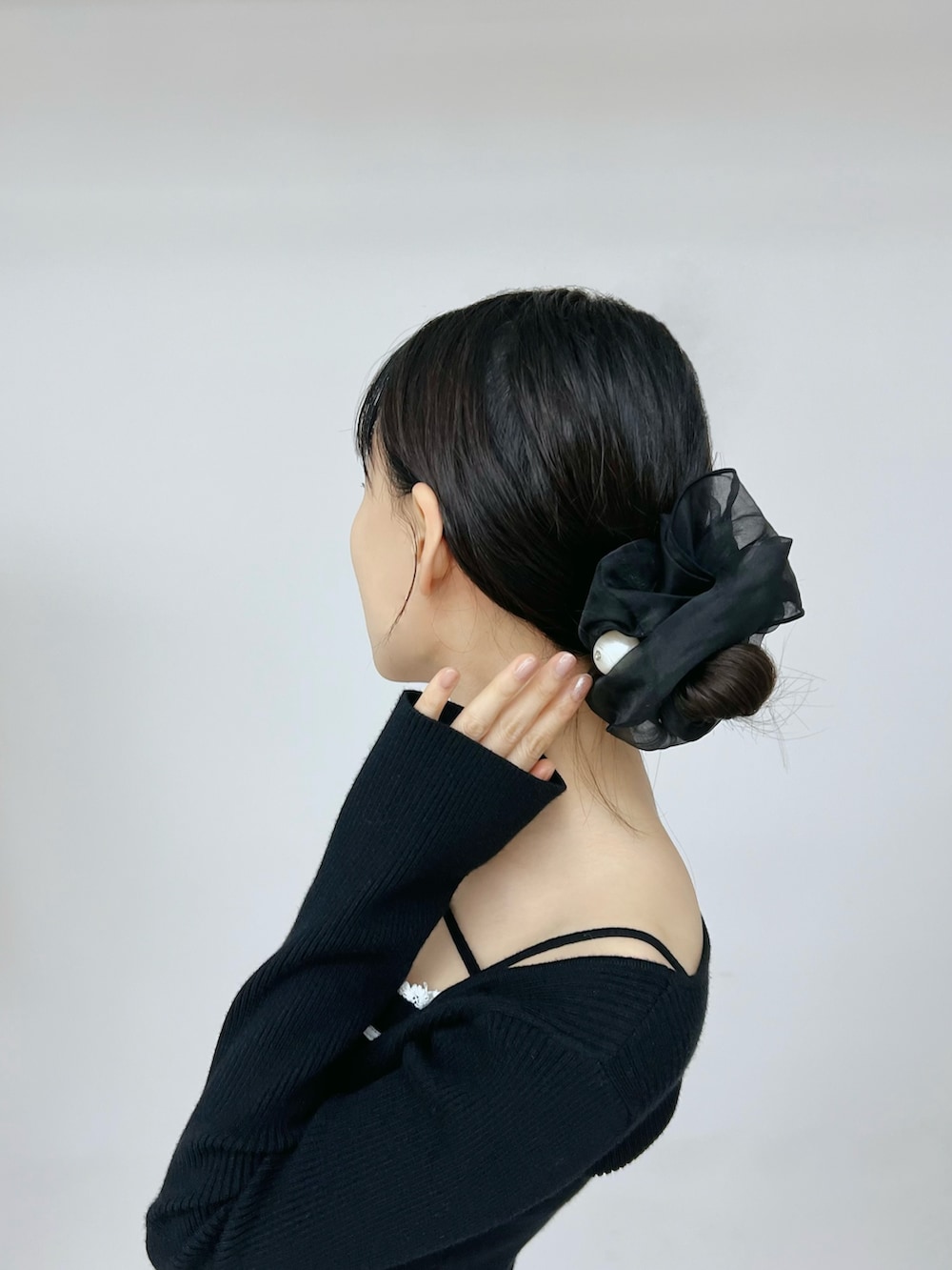 ブラック系のデニムパンツ、ブラック系のニット/セーター、ブラック系のブーツを着用したレディースの秋コーディネートの7枚目の写真