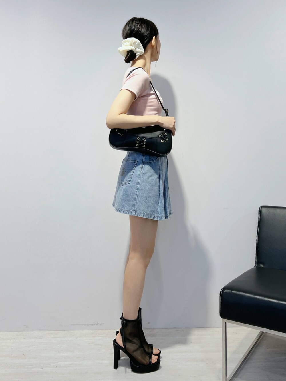 ブルー系のデニムスカート、ピンク系のTシャツ/カットソー、ブラウン系のショルダーバッグを着用したレディースの夏コーディネートの2枚目の写真