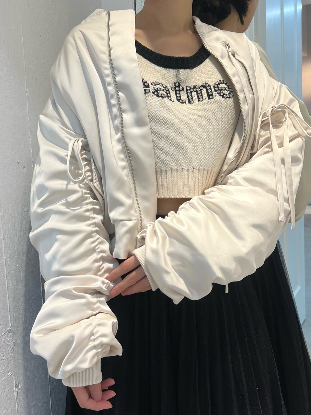 ホワイト系のニット/セーター、ホワイト系のブルゾンを着用したレディースの冬コーディネートの2枚目の写真