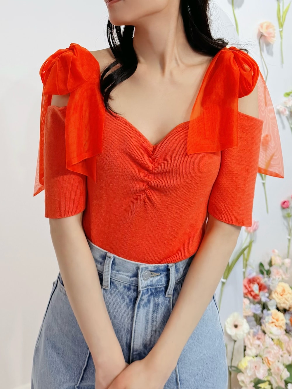 ブルー系のデニムパンツ、オレンジ系のTシャツ/カットソー、ホワイト系のブーツを着用したレディースの春コーディネートの5枚目の写真