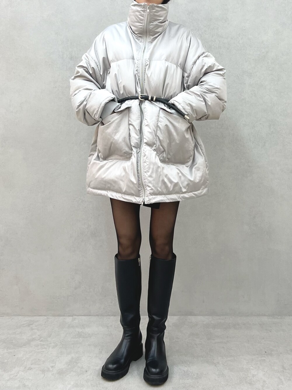 グレー系のブルゾン、ブラック系のハンドバッグ、ブラック系のベルトを着用したレディースの冬コーディネートの2枚目の写真