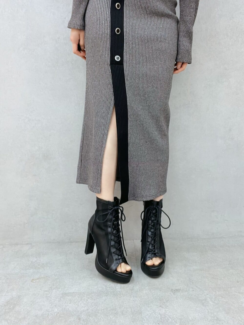 ブラック系のブーツ、グレー系のスカート、グレー系のTシャツ/カットソーを着用したレディースの冬コーディネートの5枚目の写真