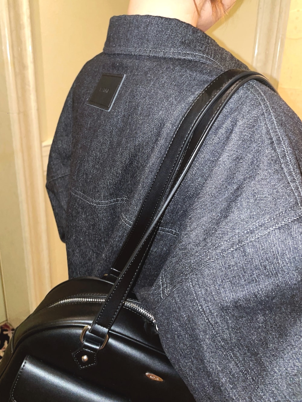 ブラック系のデニムジャケット、ブラック系のデニムパンツ、ピンク系のニット/セーターを着用したレディースの冬コーディネートの4枚目の写真