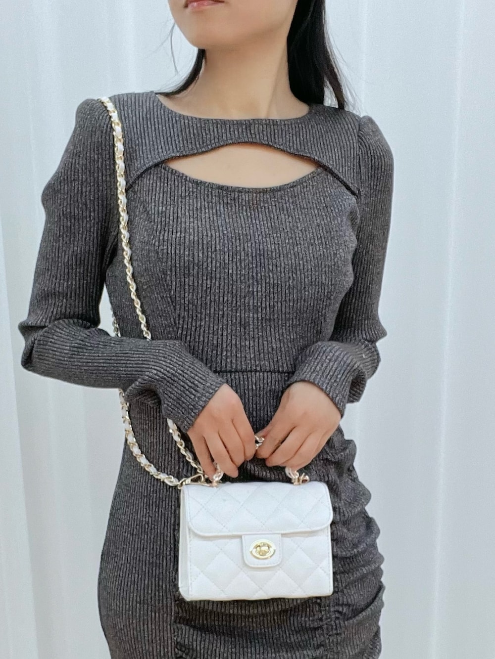 グレー系のワンピース、ホワイト系のブーツ、ホワイト系のハンドバッグを着用したレディースの冬コーディネートの5枚目の写真