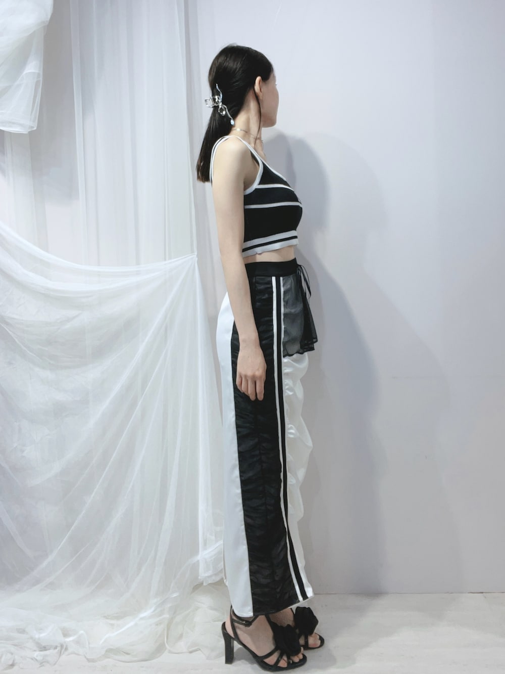 ブラック系のタンクトップ、ブラック系のハンドバッグ、ブラック系のサンダルを着用したレディースの春コーディネートの3枚目の写真