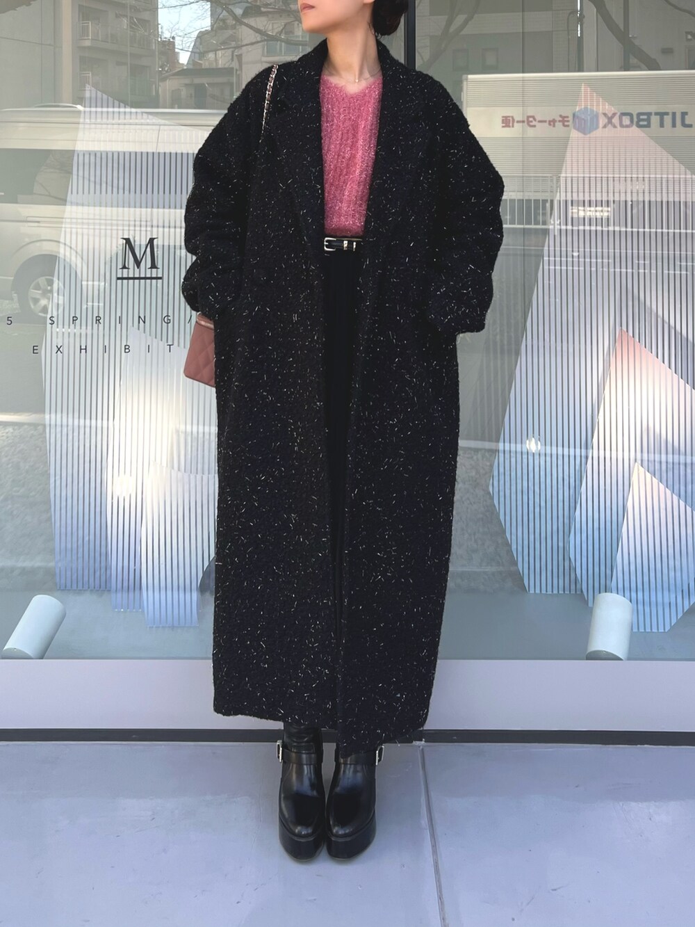 ピンク系のハンドバッグ、ブラック系のチェスターコート、ブラック系のブーツを着用したレディースの冬コーディネートの4枚目の写真