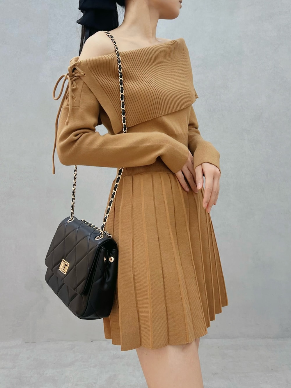 ブラウン系のワンピース、ブラウン系のブーツ、ブラック系のハンドバッグを着用したレディースの秋コーディネートの5枚目の写真