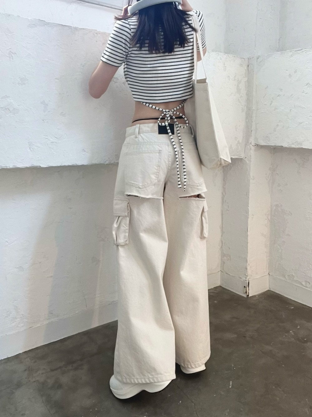 ホワイト系のデニムパンツ、その他のTシャツ/カットソー、ホワイト系のブーツを着用したレディースの春コーディネートの4枚目の写真
