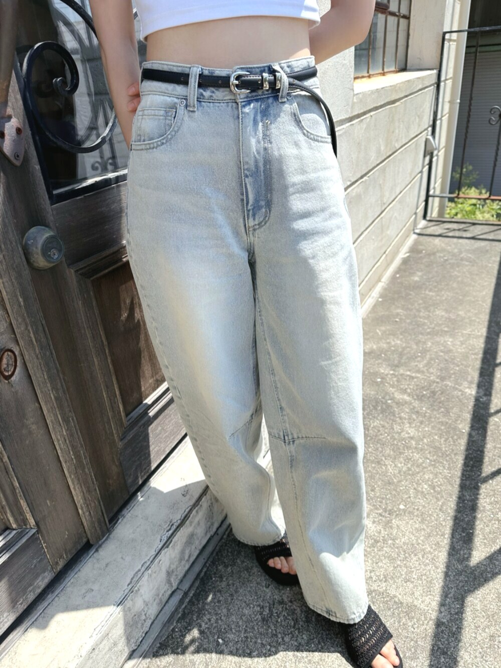 ホワイト系のTシャツ/カットソー、ブルー系のデニムパンツ、ブラック系のベルトを着用したレディースの夏コーディネートの6枚目の写真