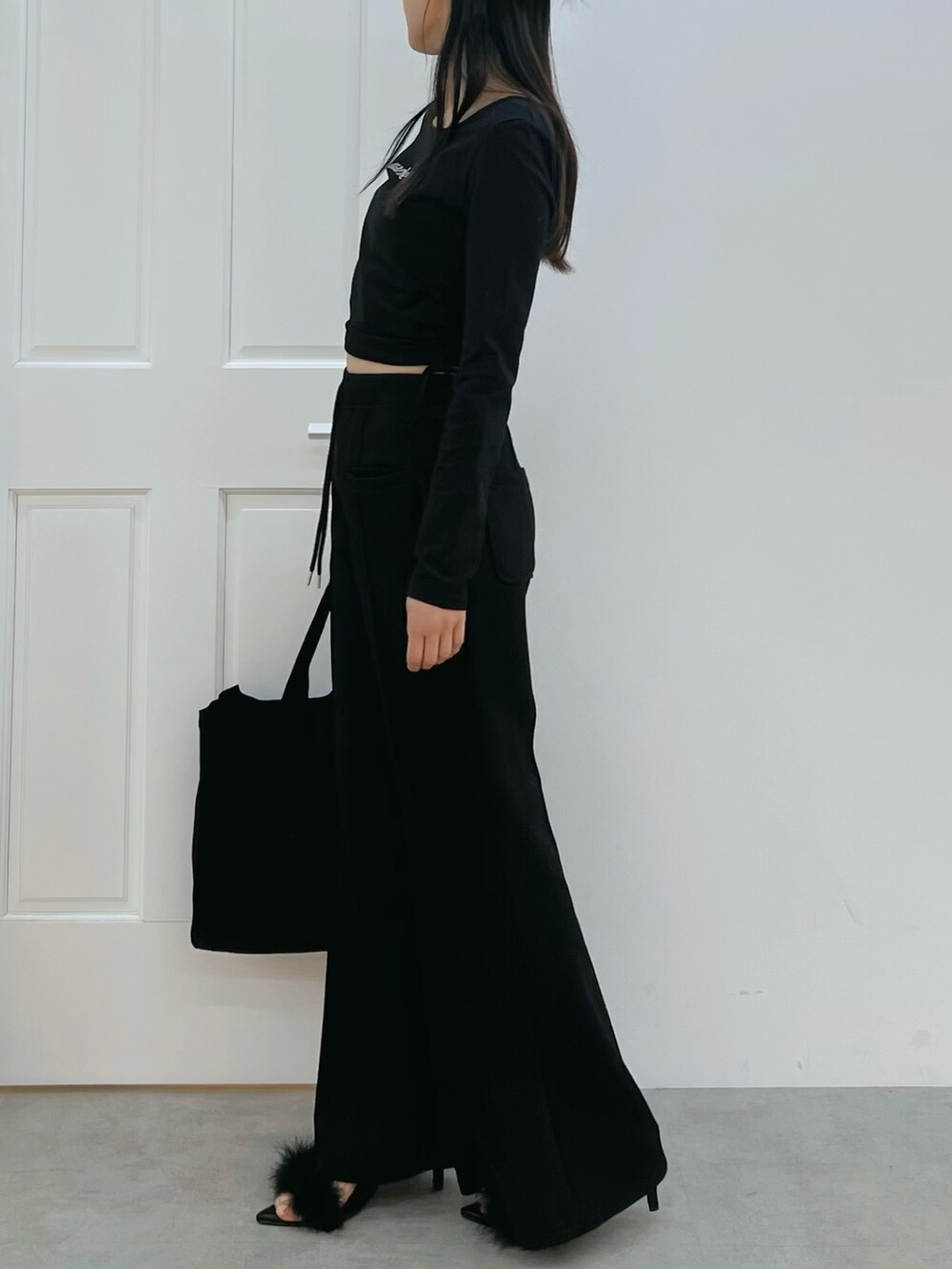 ブラック系のその他パンツ、ブラック系のTシャツ/カットソー、ブラック系のトートバッグを着用したレディースの冬コーディネートの2枚目の写真