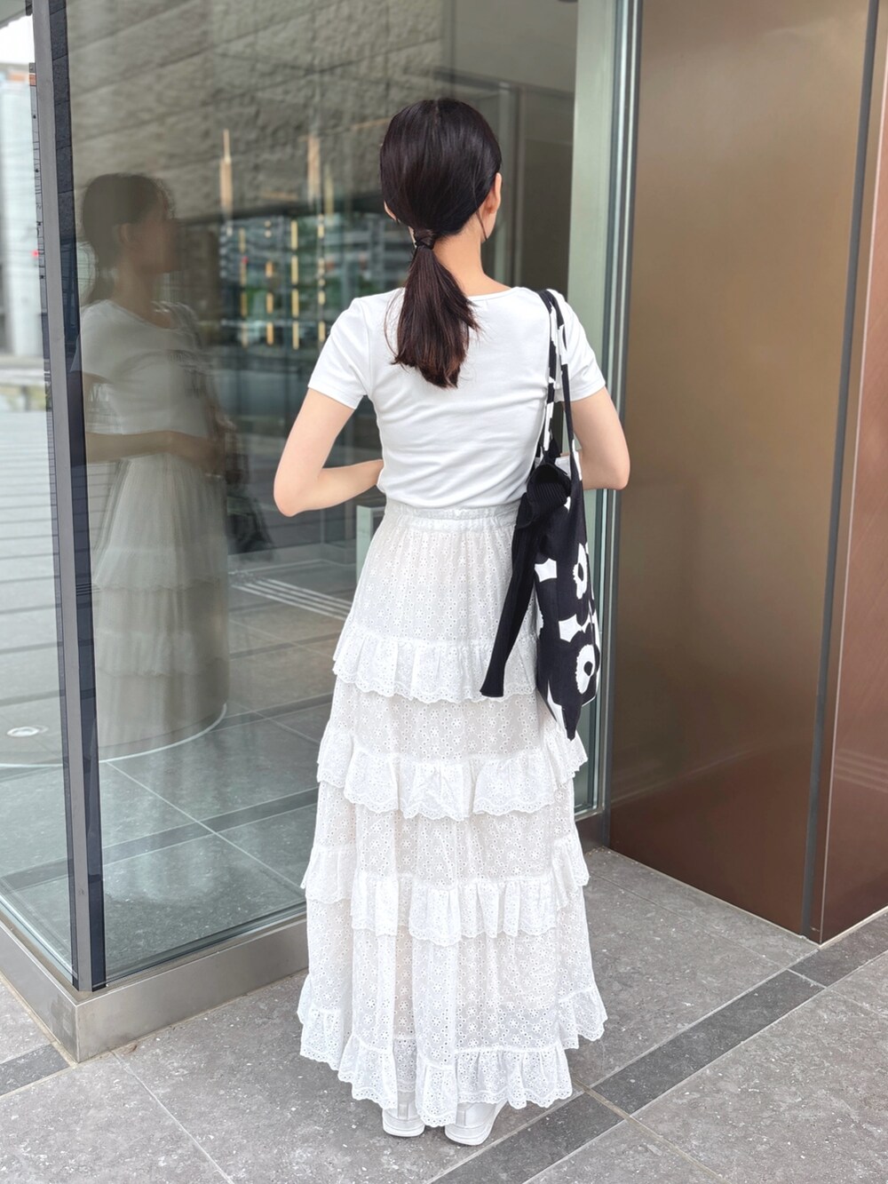 ホワイト系のスカート、ホワイト系のTシャツ/カットソーを着用したレディースの夏コーディネートの3枚目の写真