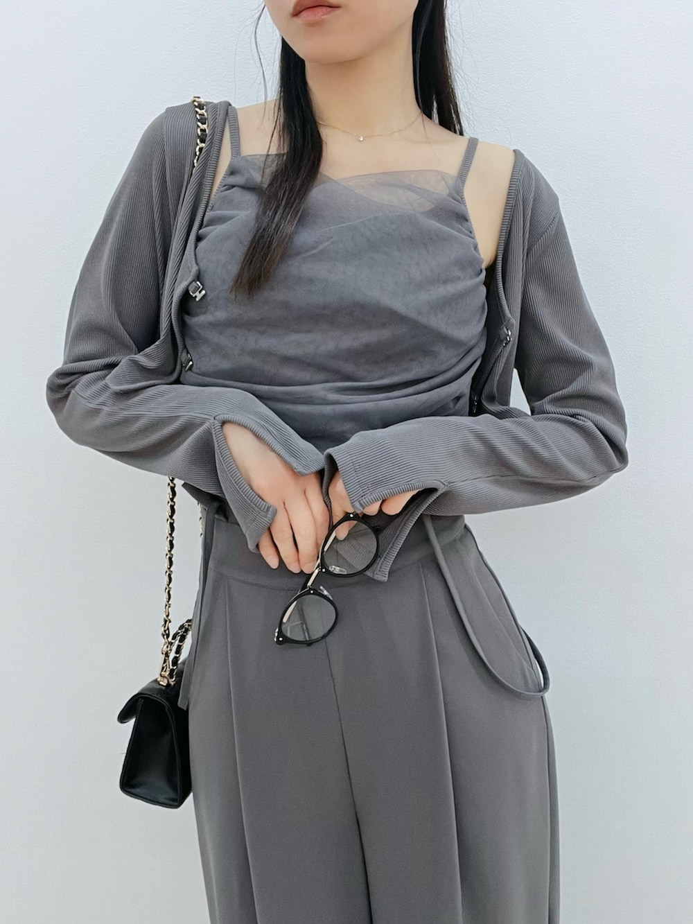 ブラック系のハンドバッグ、ブラック系のサンダル、グレー系のその他パンツを着用したレディースの春コーディネートの6枚目の写真