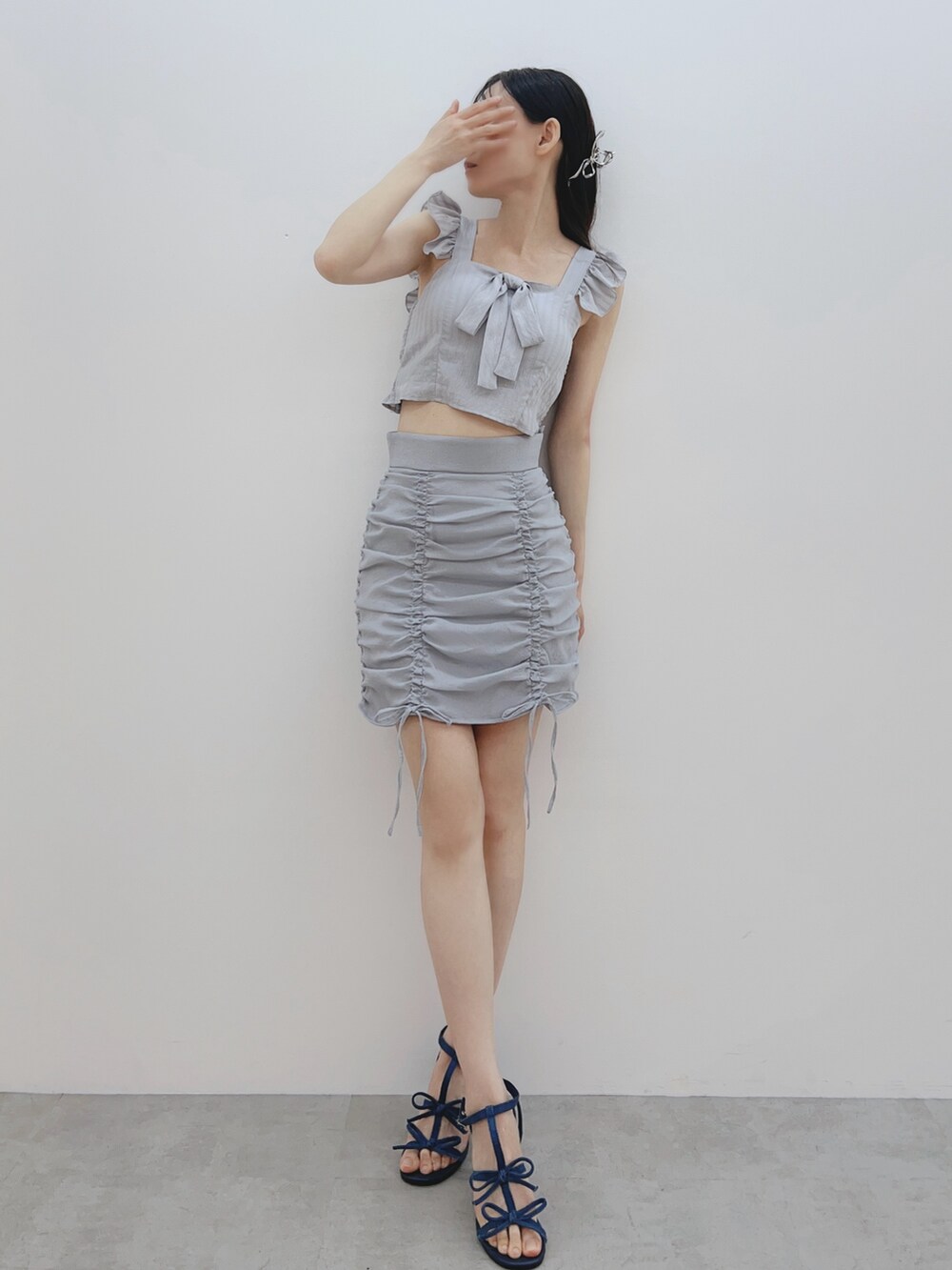 グレー系のシャツ/ブラウス、ブルー系のスカート、ブルー系のサンダルを着用したレディースの春コーディネートの3枚目の写真