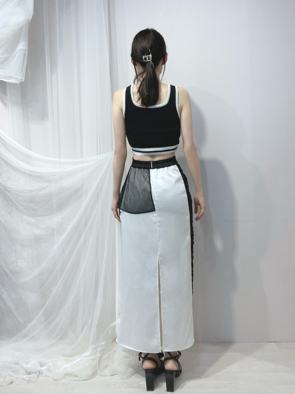 ブラック系のタンクトップ、ブラック系のハンドバッグ、ブラック系のサンダルを着用したレディースの春コーディネートの4枚目の写真