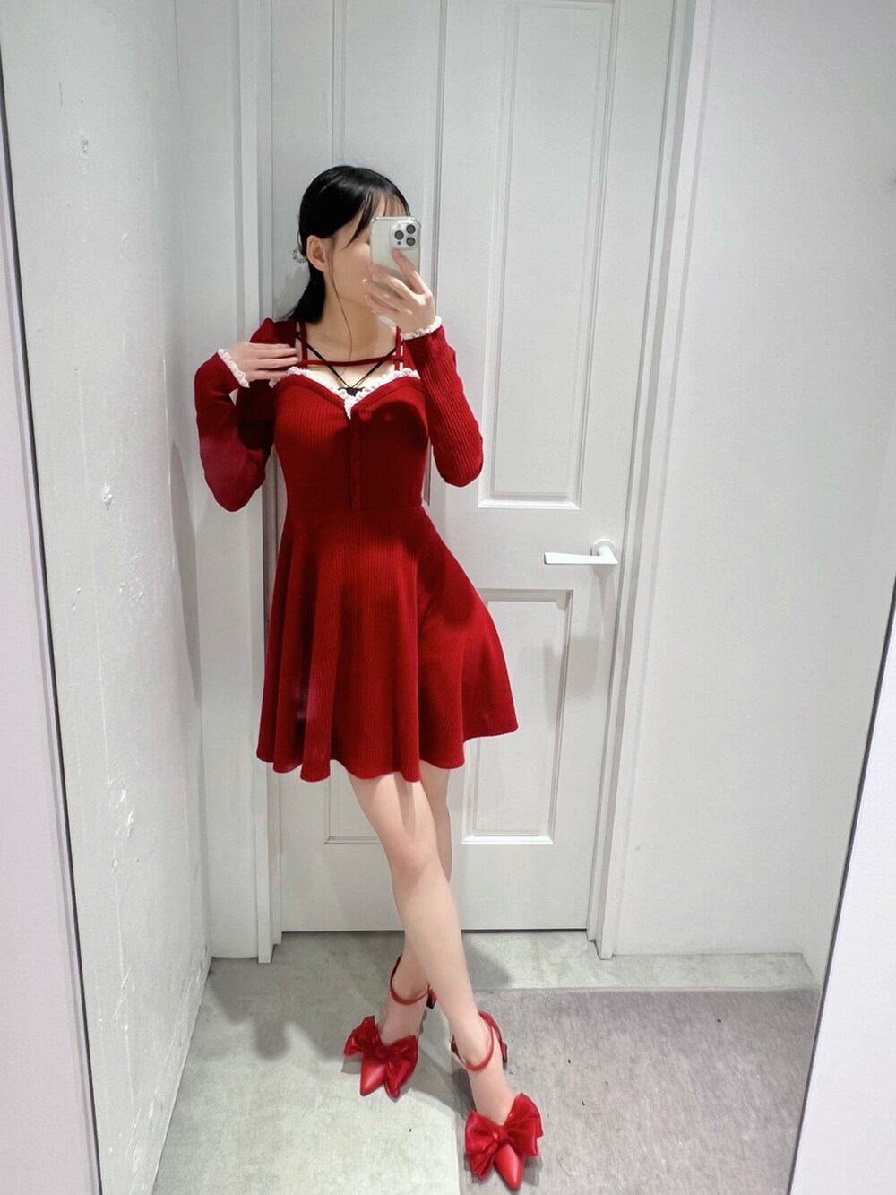 レッド系のワンピース、レッド系のパンプス、ブラック系のキャミソールを着用したレディースの冬コーディネートの2枚目の写真