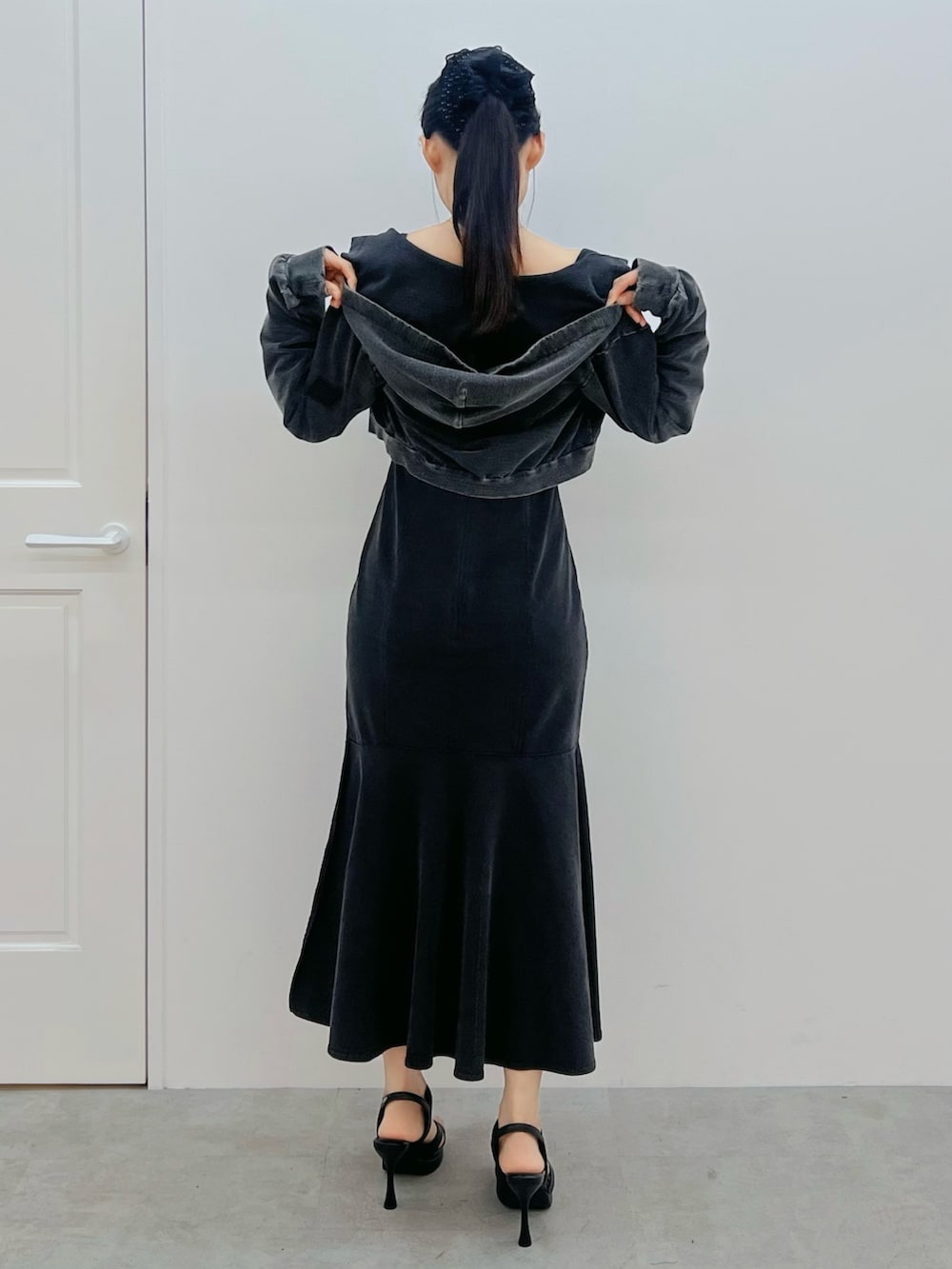 ブラック系のワンピース、ブラック系のサンダル、ブラック系のパーカーを着用したレディースの春コーディネートの3枚目の写真