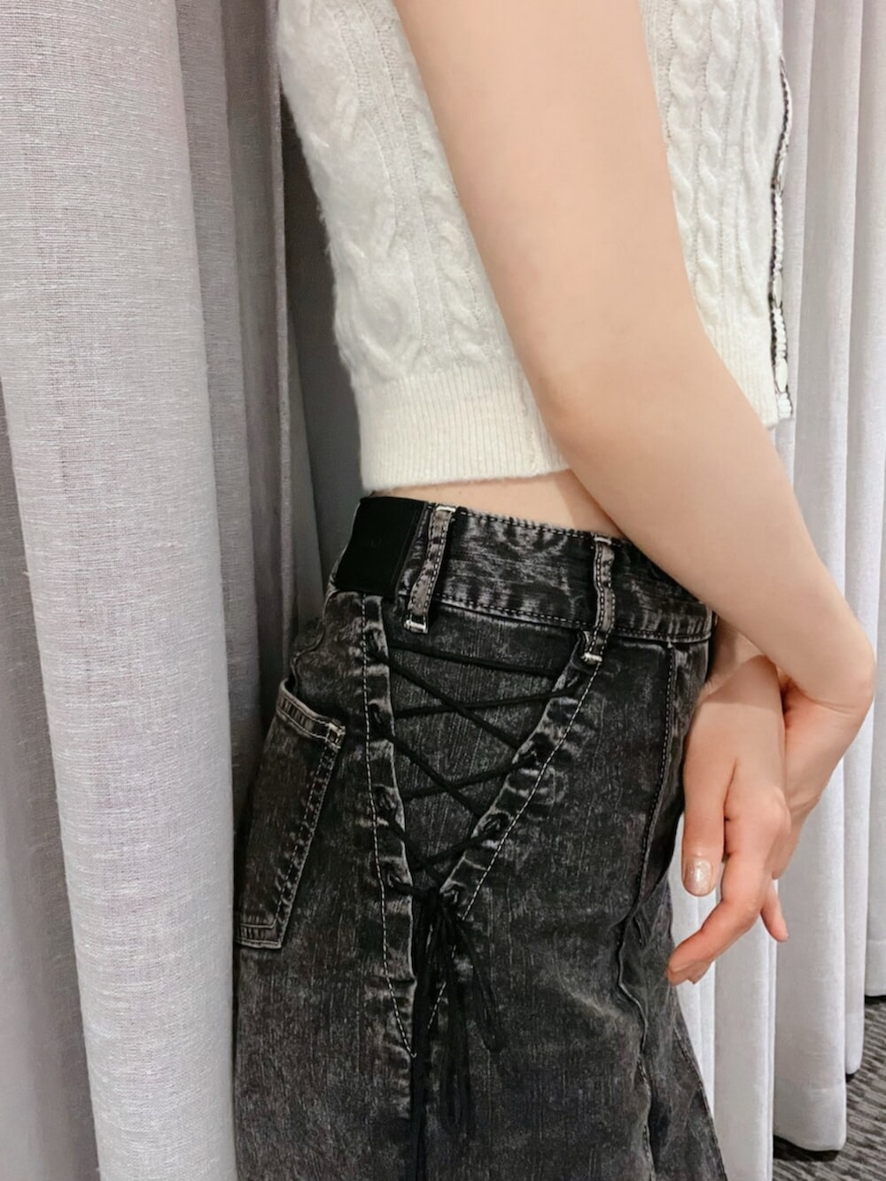 ホワイト系のニット/セーター、ブラック系のデニムパンツ、ゴールド系のネックレスを着用したレディースの秋コーディネートの8枚目の写真