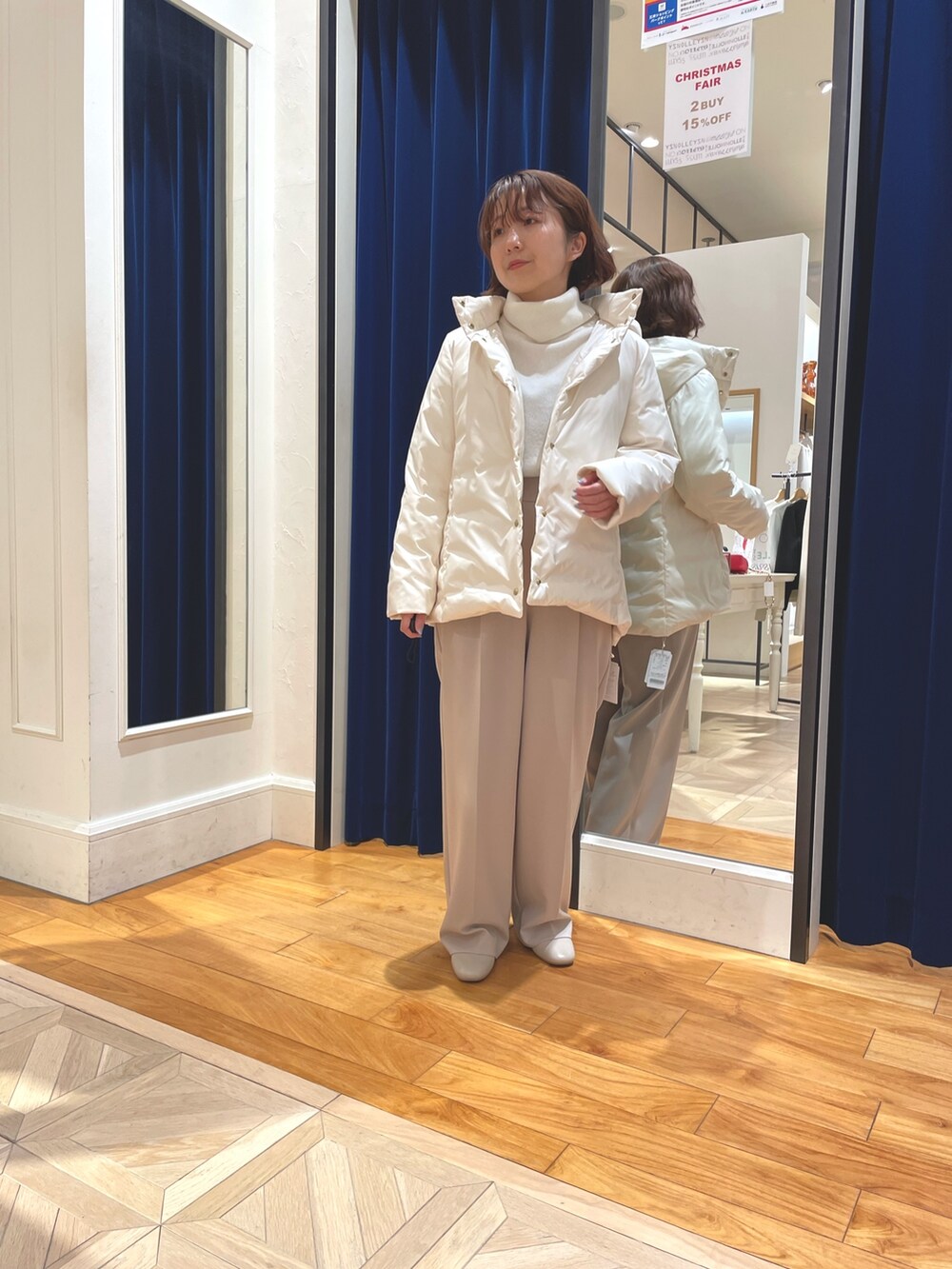 ホワイト系のダウンジャケット/コート、ベージュ系のその他パンツ、ホワイト系のニット/セーターを着用したレディースの冬コーディネートの4枚目の写真