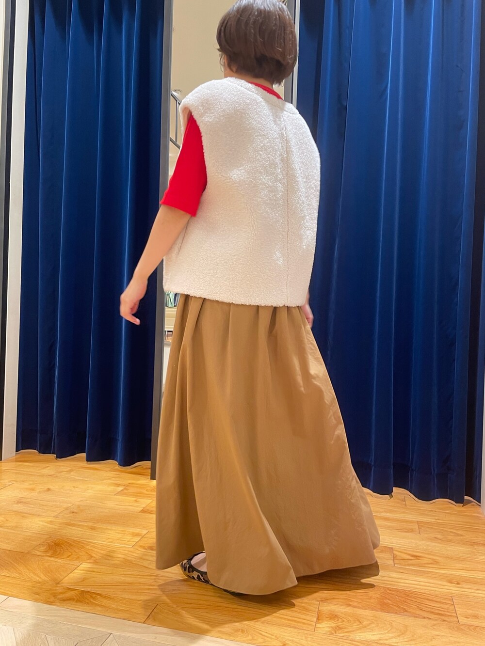 ホワイト系のベスト、イエロー系のスカート、レッド系のTシャツ/カットソーを着用したレディースの夏コーディネートの3枚目の写真