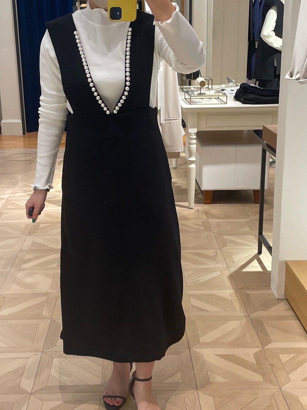 ブラック系のワンピース、ホワイト系のTシャツ/カットソーを着用したレディースの冬コーディネートの2枚目の写真