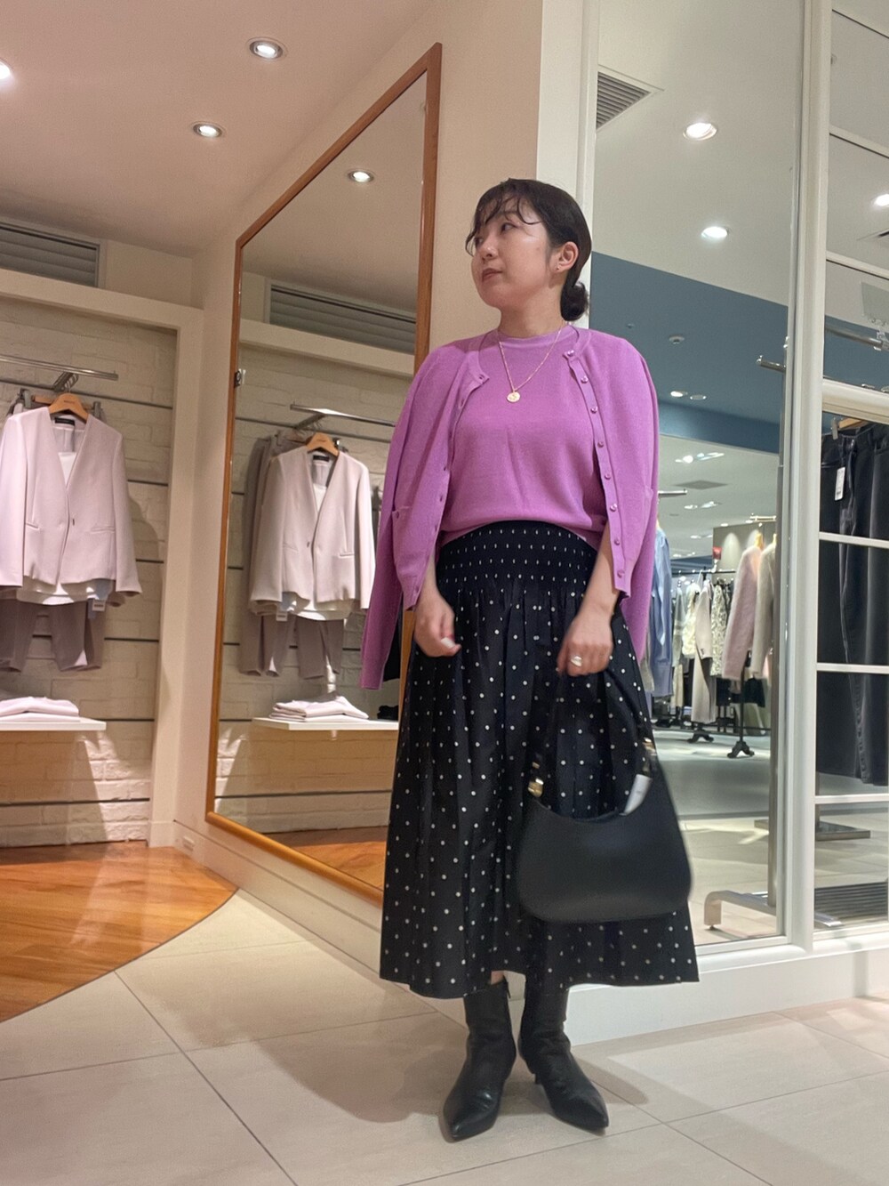 ピンク系のカーディガン/ボレロ、ピンク系のニット/セーター、ブラック系のスカートを着用したレディースの秋コーディネートの4枚目の写真