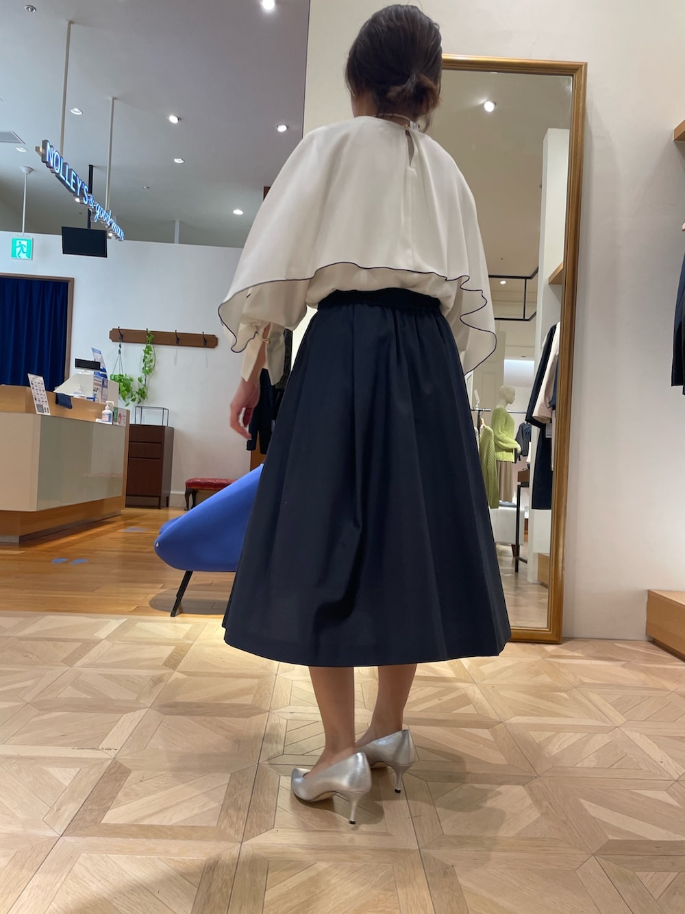 ホワイト系のシャツ/ブラウス、ブルー系のスカート、ブラック系のショルダーバッグを着用したレディースの春コーディネートの4枚目の写真