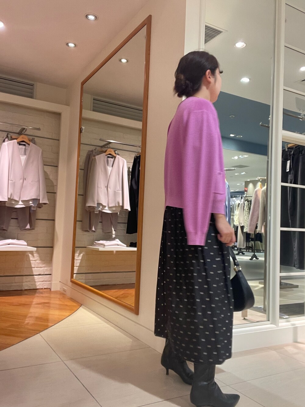 ピンク系のカーディガン/ボレロ、ピンク系のニット/セーター、ブラック系のスカートを着用したレディースの秋コーディネートの6枚目の写真