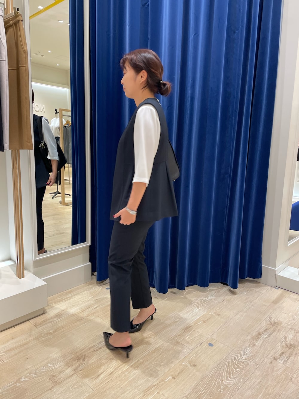 ブルー系のベスト、ブルー系のその他パンツ、ホワイト系のシャツ/ブラウスを着用したレディースの秋コーディネートの3枚目の写真